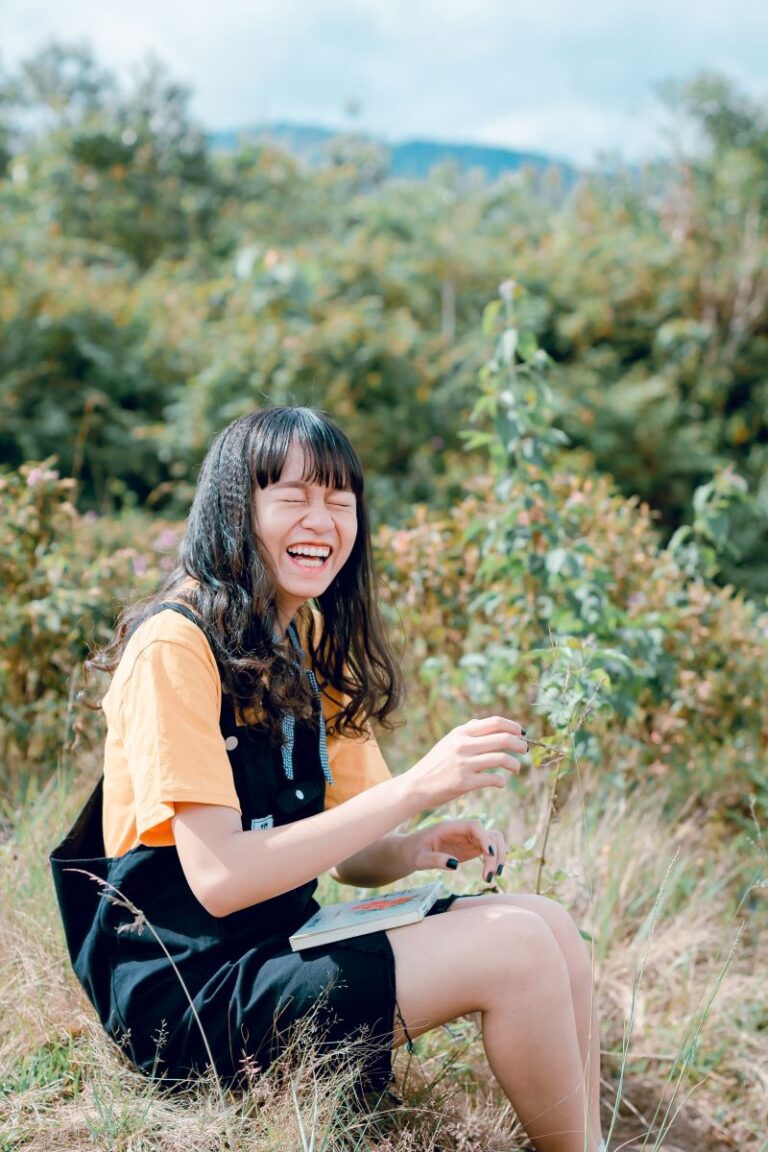 laughing woman wearing sitting on grass