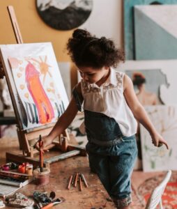 from Pexels: https://www.pexels.com/photo/a-girl-holding a paint brush in a container with water