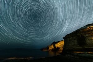 light circles on sky over rocks at night