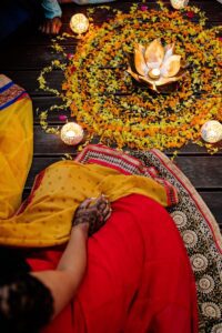 person sitting in front of a flower arrangement wearing a traditional clothes during Diwali