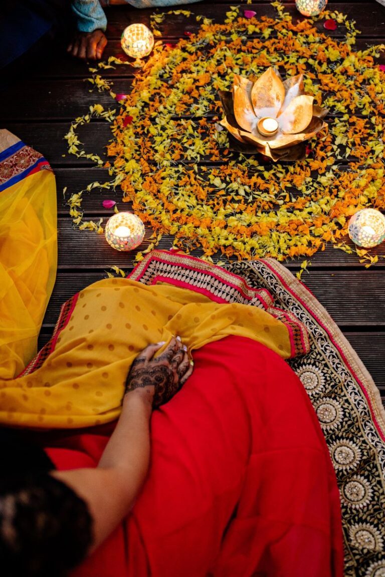 person sitting in front of a flower arrangement wearing a traditional clothes during Diwali