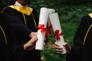 photograph of peoples hands holding white diplomas