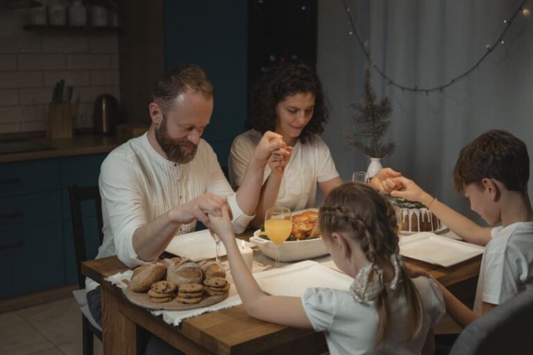 a family holding hand in saying a prayer
