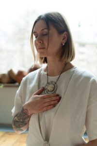 a woman holding her chest while eyes closed